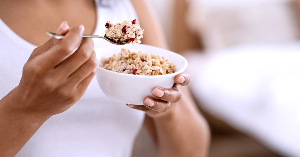 Imagen mujer comiendo avena en el desayuno 